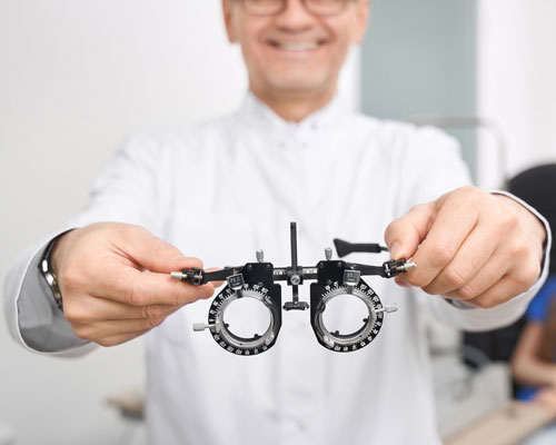Optometrista se zkušební obrubou pro vyšetření zraku